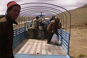 Tibetans clear out the truck to fit the crippled 
Aston Martin.